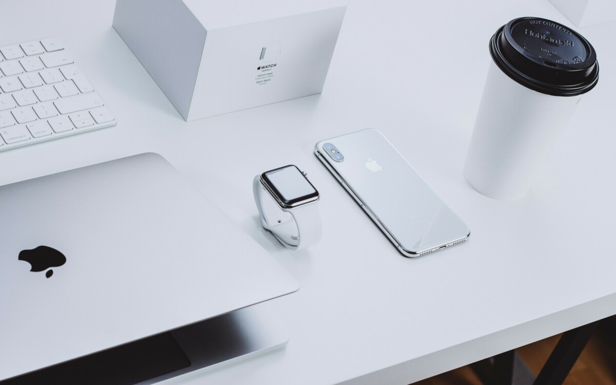 Apple boete; Een bureau met een iphone, koffie en een macbook